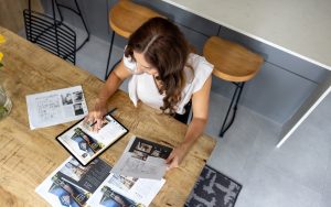 Fiatal nő ingatlanhirdetések között válogat.