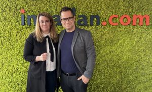 Dr. Tóth Judit Lenke adatvédelmi szakjogász (balra) és Balog László, az ingatlan.com vezető gazdasági szakértője (jobbra) az ingatlan.com podcast stúdiójában. Mögöttük zöld mohafalon az ingatlan.com logója.