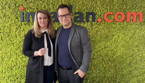 Dr. Tóth Judit Lenke adatvédelmi szakjogász (balra) és Balog László, az ingatlan.com vezető gazdasági szakértője (jobbra) az ingatlan.com podcast stúdiójában. Mögöttük zöld mohafalon az ingatlan.com logója.
